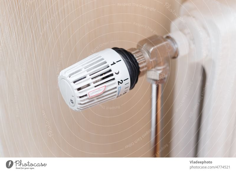 Hand dreht den Thermostat eines Heizkörpers, spart Energie, reduziert  Energiekosten - ein lizenzfreies Stock Foto von Photocase