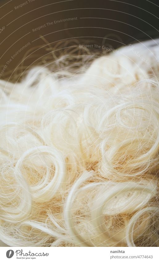 Strukturiertes Bild einer Nahaufnahme des platinblonden Haars einer Kunstperücke Perücke Behaarung Textur gefärbt farbig Farbstoff Hintergrund weich sanft
