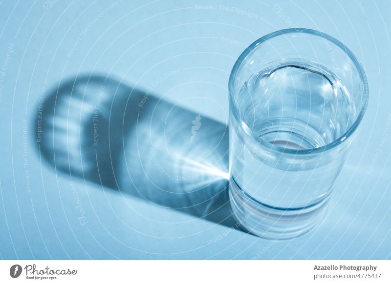 Glas mit sauberem Wasser mit Schatten in blauem Monochrom. aqua Getränk Körper Sauberkeit sauberes Wasser übersichtlich Kaltwasser Konzept konzeptionell kreativ