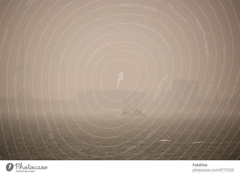 Die Skyline von Cuxhaven versinkt im Nebel. Ein kleines Schiff dümpelt in der Suppe so vor sich hin. Morgen Himmel nebelig Nebelschleier Gebäude Silhouette