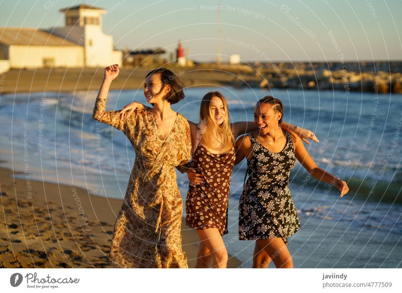 Glückliche Freundinnen gehen am Sandstrand spazieren Frauen sorgenfrei Strand MEER Umarmung genießen heiter Sonnenuntergang Freiheit Zusammensein schlendern
