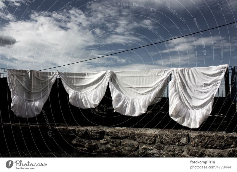 Bettlaken bzw. Spannbettücher hängen zum Trocknen auf einem Zaun Wäsche Wäscheleine Bettwäsche Spannbettlaken trocknen Wäsche waschen Waschtag Häusliches Leben