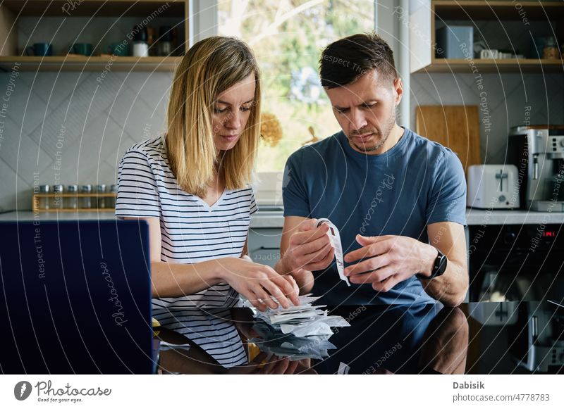 Mann und Frau sehen sich in der Küche die Zahlungsrechnungen an Familie Haushaltsplan Rechnung berechnen Hausfinanzierung Finanzen planen beunruhigt heimwärts