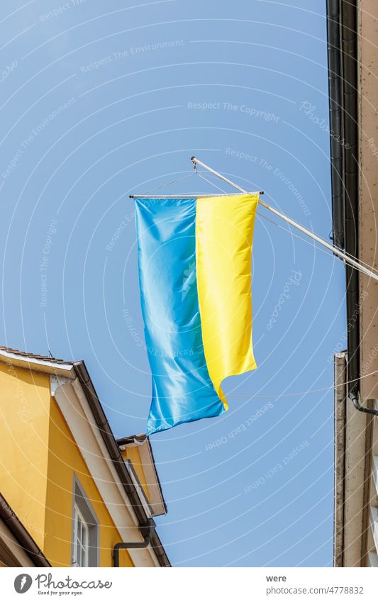 An einem Haus in der Lindauer Altstadt hängt eine ukrainische Flagge als Zeichen der Solidarität Russland Ukrainer Bayern blau Gebäude Textfreiraum Fahne