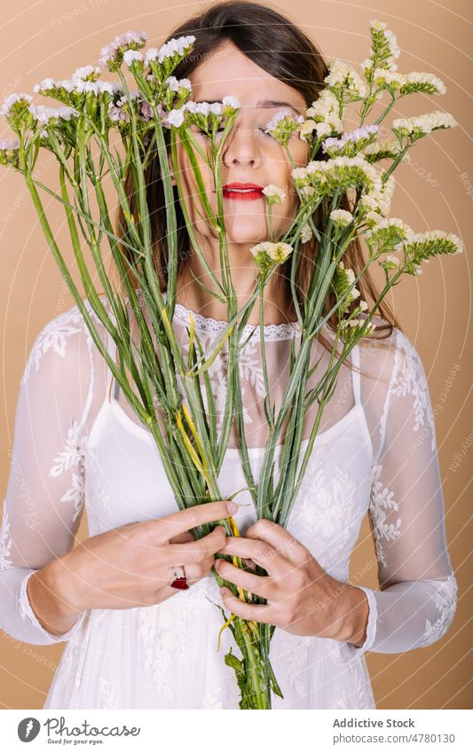 Braut im Kleid an Blumen riechend Frau weißes Kleid Hochzeit Stil Anlass Blumenstrauß geblümt Veranstaltung Augen geschlossen elegant Pflanze präsentieren
