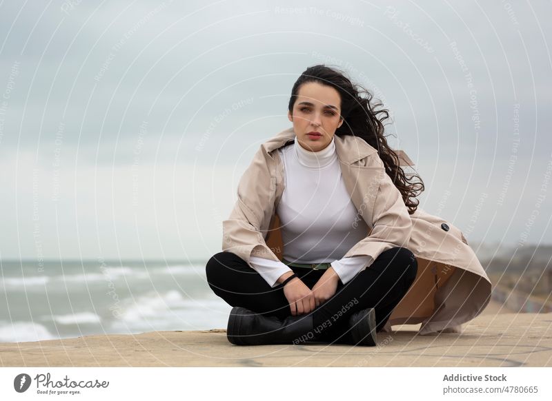 Charmante Frau am Strand an einem windigen Tag Küste Wasser MEER Wind Seeküste winken Küstenstreifen verträumt feminin fliegendes Haar Meeresufer Wetter Ufer