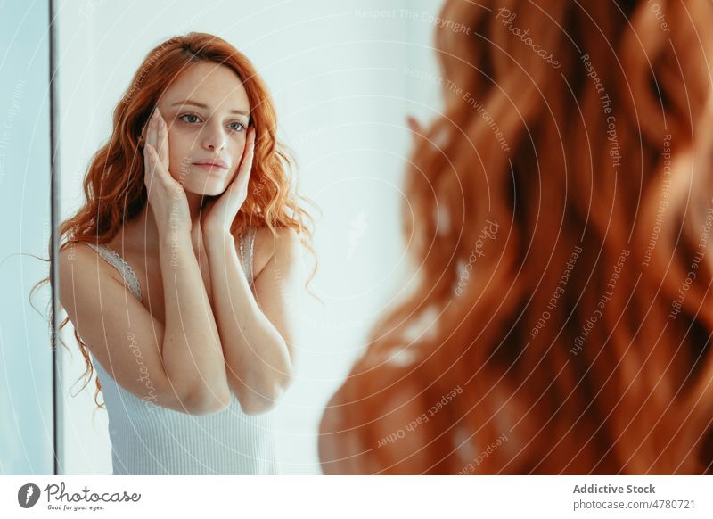 Frau berührt Gesicht im Badezimmer Spiegel Rotschopf Hygiene Routine Reflexion & Spiegelung prüfen täglich Ingwer Hautpflege Tasthals Waschbecken heimwärts