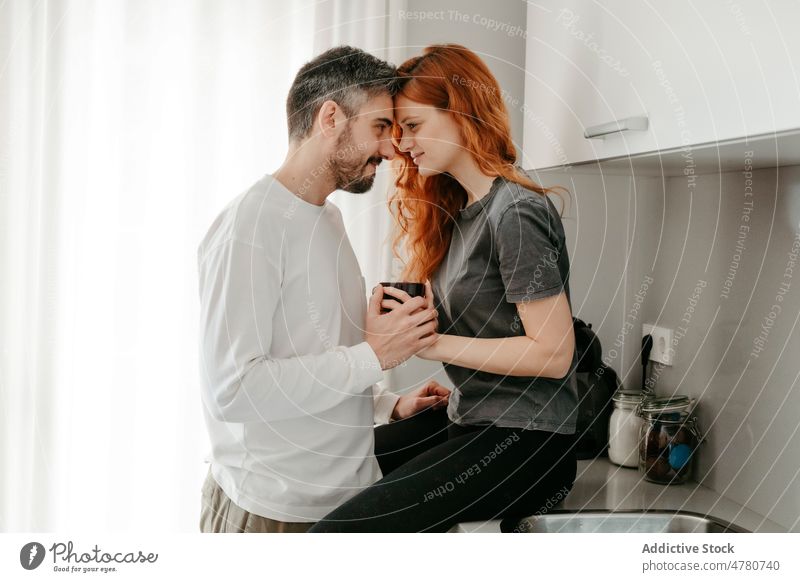 Pärchen streichelt sich auf der Küchentheke Paar Partnerschaft Liebe Bonden kuscheln romantisch Zuneigung Streicheln Rotschopf Kaffee Ingwer Zusammensein
