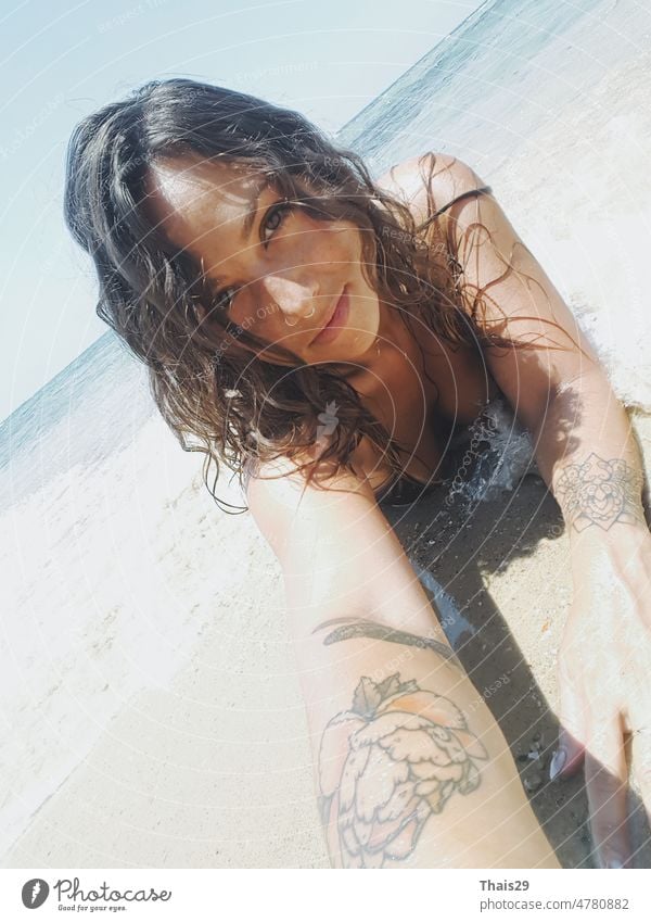 Schöne junge Frau in sexy Bikini steht am Meer Strand. Schöne Frau im violetten Bikini am tropischen Strand. Porträt eines brünetten gebräunten Mädchens in Badekleidung