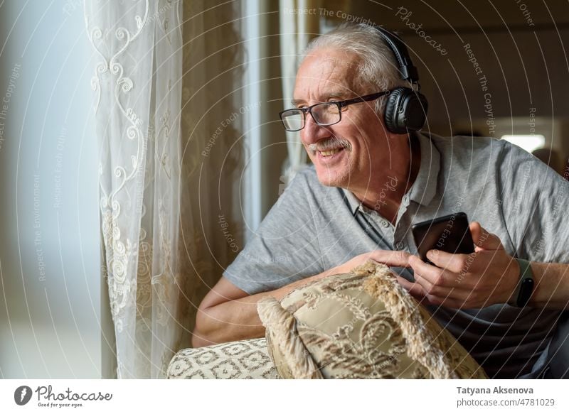 Älterer Mann hört Musik vom Telefon Person Senior Kopfhörer hören Handy männlich genießend Technik & Technologie Lifestyle reif Smartphone Erwachsener Mobile