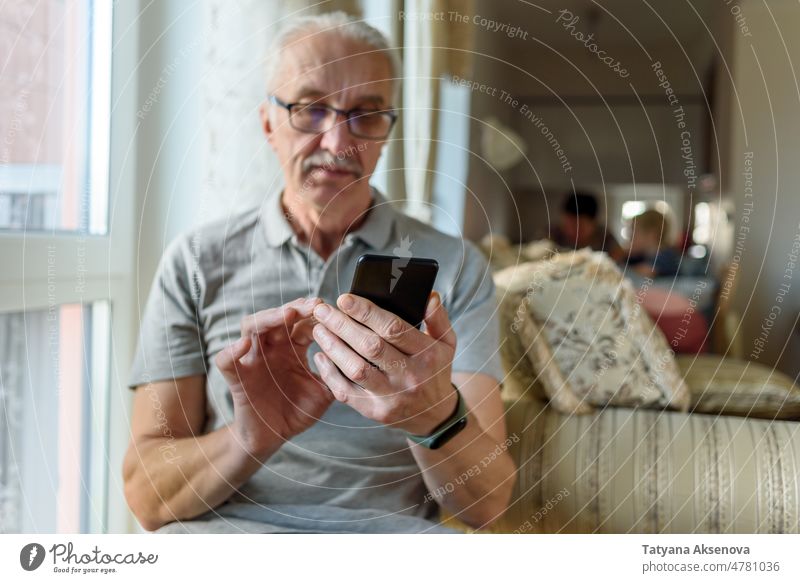 Älterer Mann mit Brille, der ein Mobiltelefon benutzt Person Senior Handy Technik & Technologie Mitteilung benutzend heimwärts reif Mobile Telefon männlich