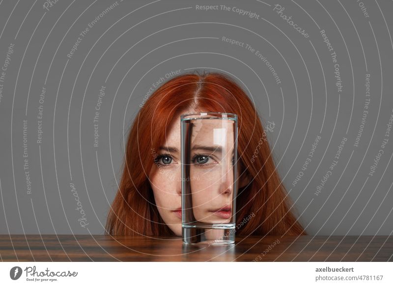 verzerrtes Gesicht einer Frau, die durch ein Glas Wasser schaut Verzerrung Selbstbeobachtung Dualität Individualität Blick Stimmung Humor surreal Identität