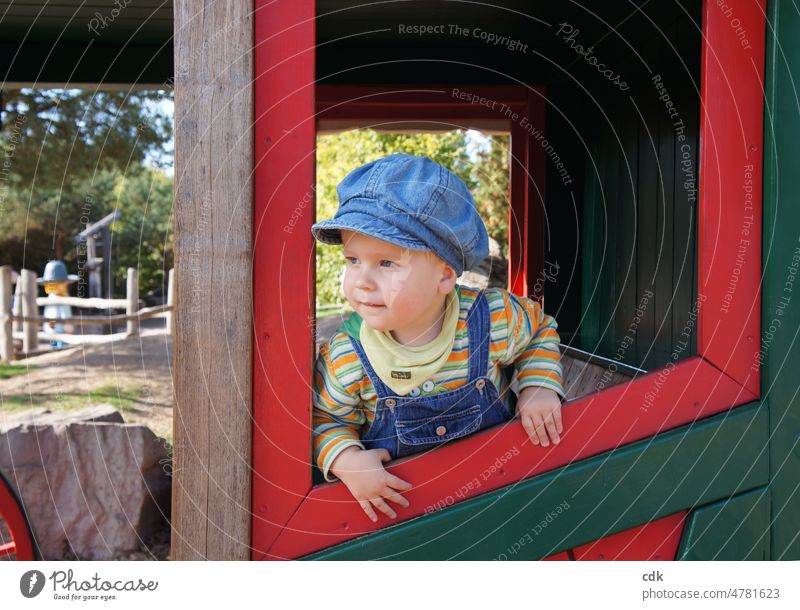 Kindheit | Kleiner Junge im Freizeitpark: unterwegs in der Postkutsche. Mensch Kleinkind kleiner Junge Jeansmütze Cap Schirmmütze Latzhose gestreift blau grün