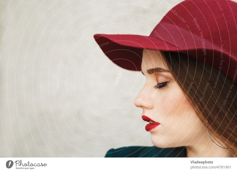 Junge schöne Frau Profil Porträt. Frau mit einem roten Hut auf dem Kopf, schönes Gesicht und weiche Haut. Behaarung Schönheit Model Mädchen Person niedlich