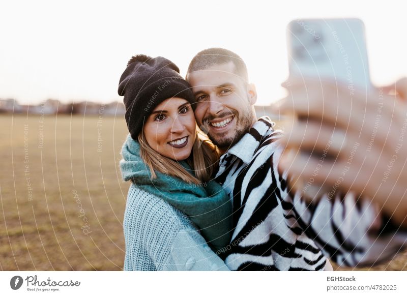 Paar nimmt ein Selfie Foto mit Handy in der Landschaft bei Sonnenuntergang Mobile Telefon Glück Zusammensein Zusammengehörigkeitsgefühl Wiese Romantik