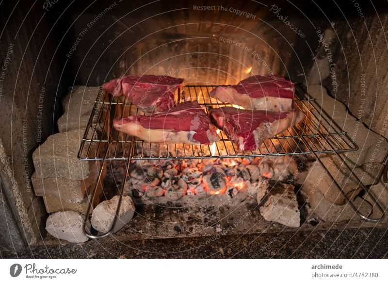 Italienisches Steak Fiorentina auf dem Grill Barbecue grillen Schornstein Nahaufnahme Koch Essen zubereiten Kuh Feuer Feuerstelle Lebensmittel gebraten