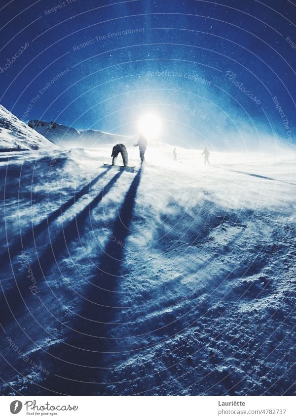 Silhouetten von Snowboardern auf einer Skipiste mit einer verschneiten Sonne Weltall Nacht Phantasie Planet Schmuckkörbchen im Freien Raum Galaxie blau Schnee