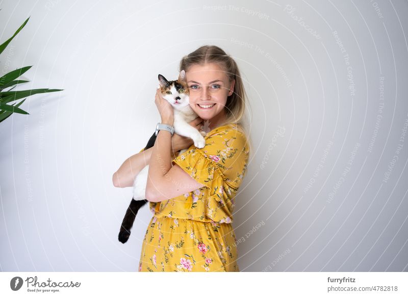 junge blonde Frau umarmt ihre Katze mit Kopierraum Kätzchen Ein Tier Tierhalter Junge Frau Person Kaukasier Mädchen blondes Haar Kleid geblümt gelb lange Haare