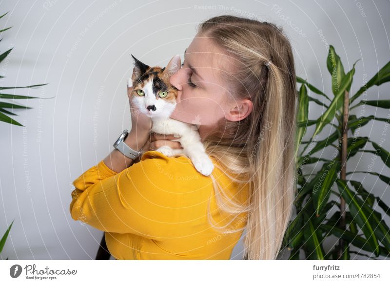 Junge Frau umarmt und küsst ihre süße Katze Kätzchen Ein Tier Tierhalter Person Kaukasier Mädchen blondes Haar Kleid gelb lange Haare schön Kattun weiß