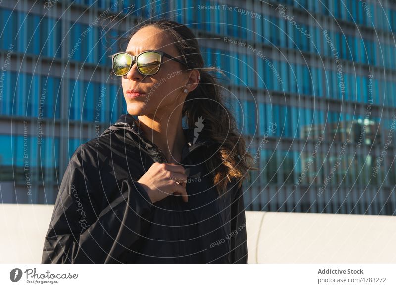 Sportlerin mit Sonnenbrille auf der Straße stehend Training Pause ausrichten Athlet pausieren Gesunder Lebensstil Sportkleidung sportlich Wohlbefinden Großstadt