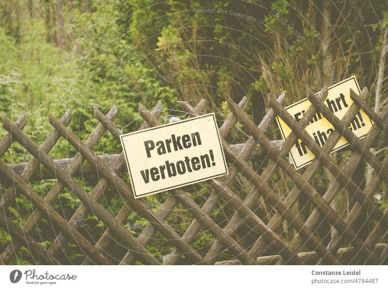 Parken  verboten Schild an einem Jägerzaun mit grünem Garten im Hintergrund parken verboten Hinweisschild Verbote Parkplatz Zeichen Schilder & Markierungen