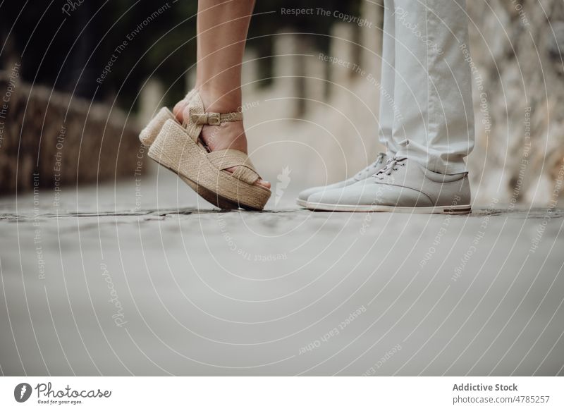 Romantisches Paar steht sich an der Sommerstraße gegenüber romantisch Straße Kuss Kieselstein Valentinsgruß Straßenbelag auf Zehenspitzen Sandalen stehen