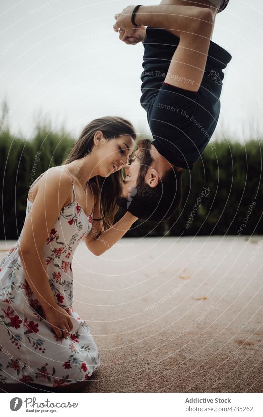 Zärtliches Paar küsst sich kopfüber auf der Landstraße Kuss auf den Kopf gestellt Angebot ländlich lässig kreativ erhängen Landschaft Valentinsgruß Bonden