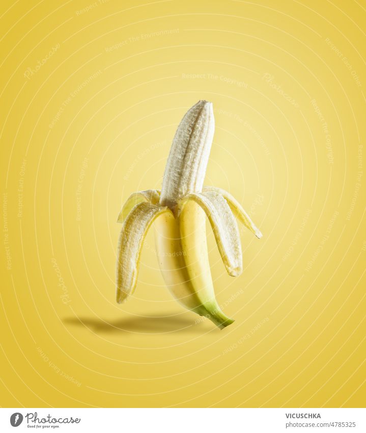 Halb geschälte Banane im Sonnenlicht auf gelbem Hintergrund Hälfte lecker tropische Früchte Vorderansicht Lebensmittel frisch Frucht halb gepellt Gesundheit