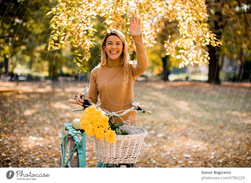 Glückliche aktive Frau beim Fahrradfahren im Herbstpark Radfahren lässig Kaukasier Zyklus genießen Genuss fallen Laubwerk Wald Gesundheit Blätter Freizeit