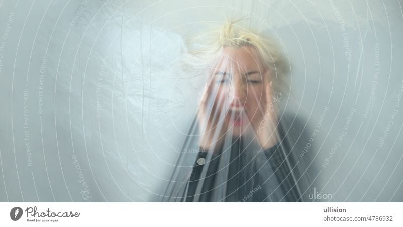 Panoramabanner mit unscharfem Porträt einer jungen blonden Frau hinter transparenter Plastikfolie als Symbol für Angst, Panik, Sorge und Verzweiflung