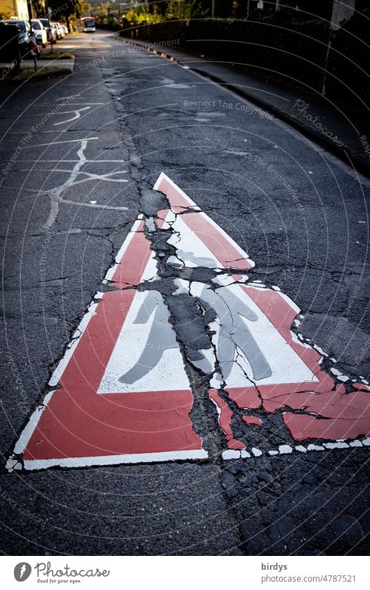 Vorsicht Kinder, beschädigte Fahrbahnmarkierung auf stark beschädigtem Straßenasphalt. Sanieringsstau Straßeninfrastruktur Schulweg Straßenschäden