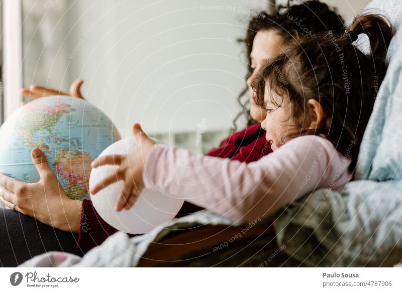 Mutter und Tochter spielen mit dem Erdglobus Erde Erdkugel Globus Ferien & Urlaub & Reisen Planet Kugel Farbfoto blau Geografie Kontinente Globalisierung
