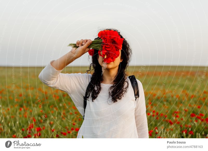Porträt eines Mädchens, das sein Gesicht mit Mohnblumen bedeckt Frau Mohnblüte Mohnfeld Sommer Blume Blüte Außenaufnahme Natur Pflanze authentisch rot Mohnwiese