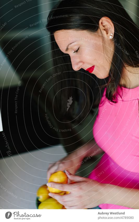 Frau, die in ihrer Küche Zitronen in eine Schüssel legt Apfel Banane Kalorien Pflege Kaukasier Kanal Küchenchef Zitrusfrüchte Essen zubereiten geschnitten