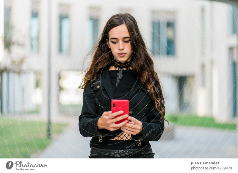 Junge Frau in Schwarz, die draußen telefoniert jung Schwarze Farbe Kleidung rot Großstadt Vorderansicht benutzend Telefon Gebäude eine Person im Freien