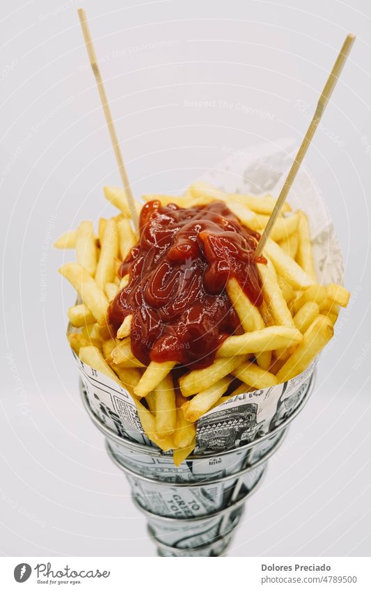 Pommes-Tüte mit Ketchup zum Mitnehmen Amerikaner Amuse-Gueule Hintergrund gebacken Korb Eimer Kalorien Schachtel Chips Nahaufnahme Farbe Container gekocht
