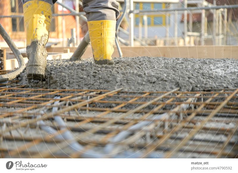 Bauarbeiter auf einer Baustelle beim Betonieren Zement Gummistiefel Handwerker Arbeiter gelb Eisen Metall Hausbau betonieren arbeiten Maurer bauen estrich Stahl
