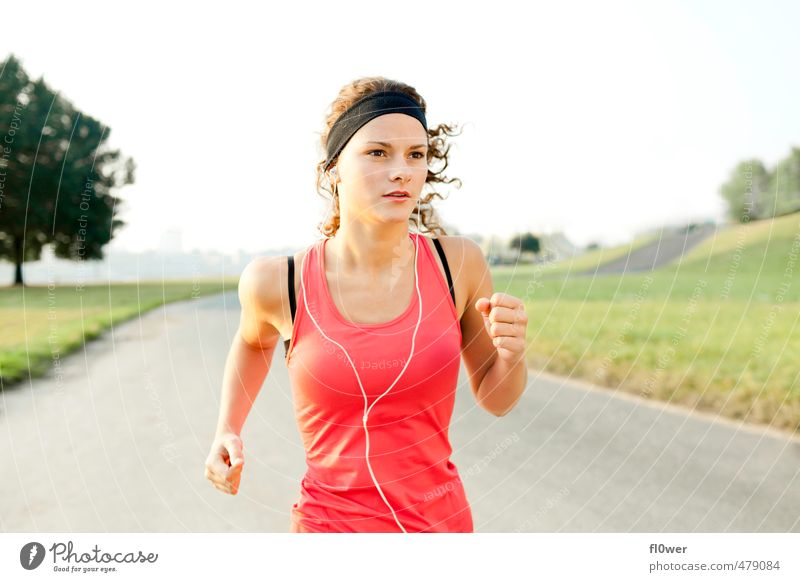 Frau joggt auf Asphalt Straße in der Natur mit Kopfhörern Sport feminin Junge Frau Jugendliche 1 Mensch 13-18 Jahre Kind 18-30 Jahre Erwachsene Wiese