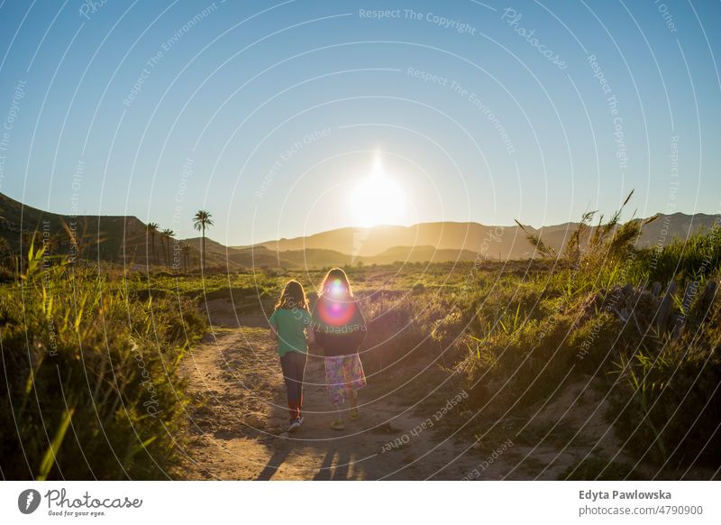 Zwei Mädchen wandern in der Natur bei Sonnenuntergang Playazo de Rodalquilar aktiv Aktivität Abenteuer schön Kind Kindheit Landschaft Tag Fundstück erkunden