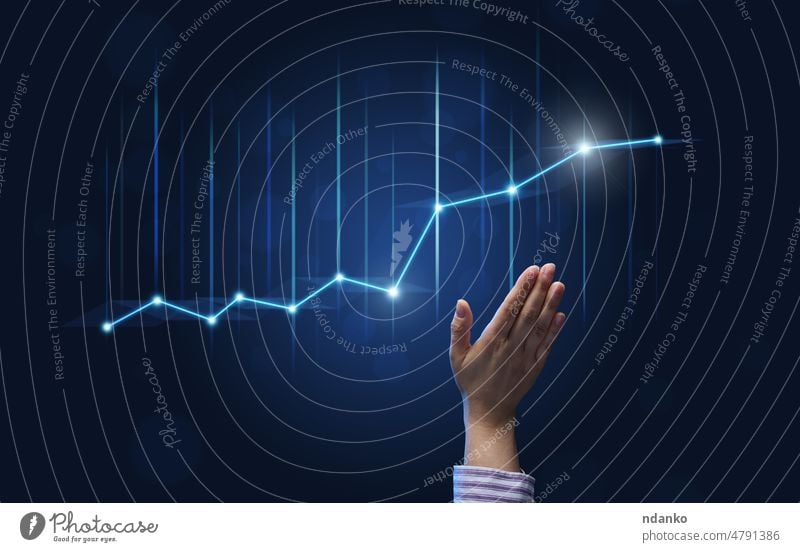 Die Hand eines Geschäftsmannes zeigt auf ein holografisches Diagramm mit steigenden Zinsen auf blauem Hintergrund. Entwicklung eines Unternehmens mit hohen Gewinnen, die Aussicht auf die Umsetzung von Geschäftsplänen