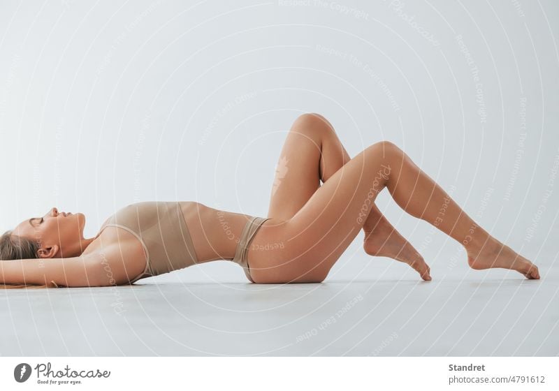 Schöner schlanker Körpertyp. Frau in Unterwäsche ist im Studio posiert Haut Beine Dessous Rücken Stil Mode Typ posierend im Innenbereich Atelier weiß Kaukasier