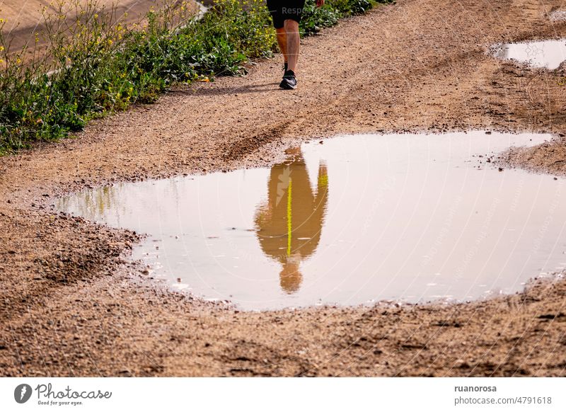 Spiegelung eines Mannes in einer Pfütze Sport Reflexion & Spiegelung Pfützenspiegelung Wasserspiegelung Außenaufnahme Wasserlache laufen Spiegelbild