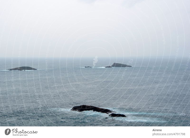 Inselreste - Restinseln Meer Horizont dunkel Urelemente düster Einsamkeit grau schlechtes Wetter Wasser Felsen umspült Wellen trostlos menschenleer einsam