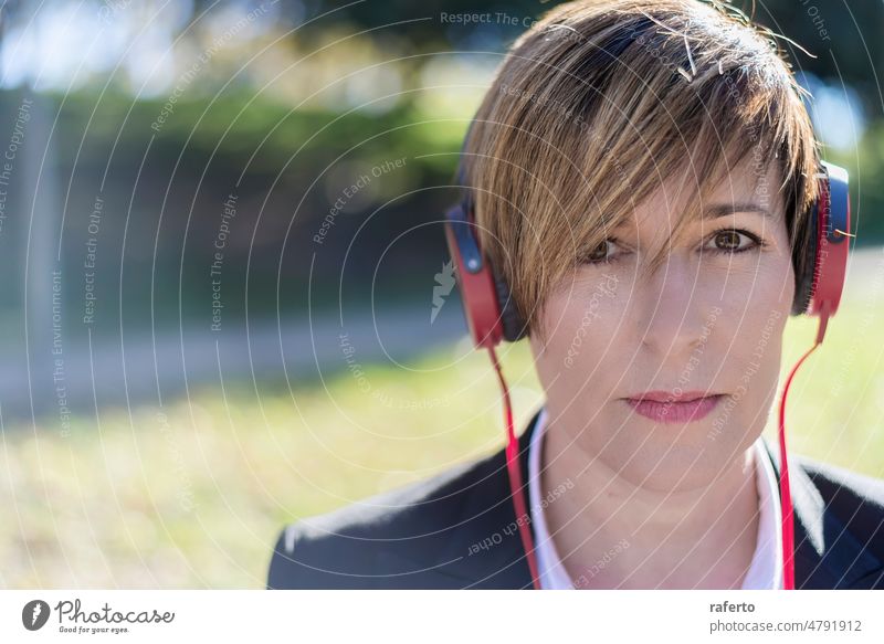 Entspannte Frau hört Musik und meditiert draußen in der Natur im Freien Bank Kopfhörer Lifestyle außerhalb Park sich[Akk] entspannen junger Erwachsener Headset