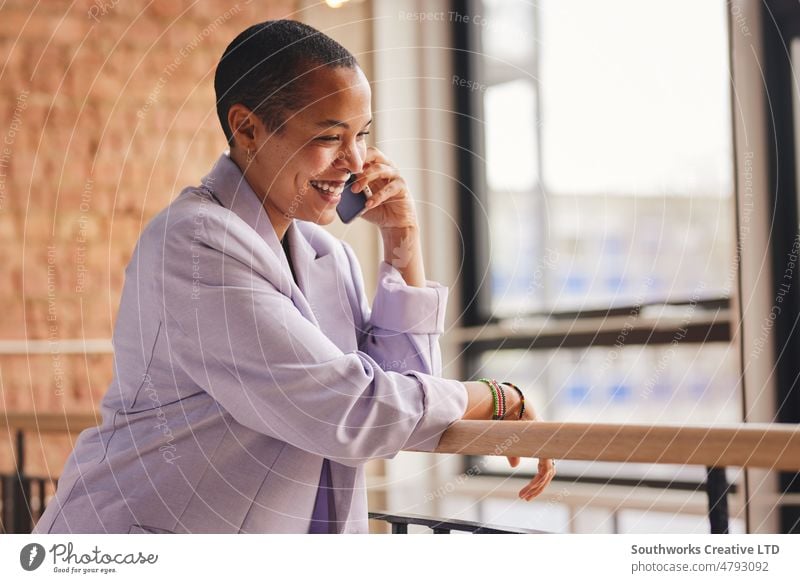 Porträt einer fröhlichen multirassischen LGBTQ-Frau im mittleren Erwachsenenalter, die sich mit einem Smartphone unterhält und lächelt heiter rassenübergreifend