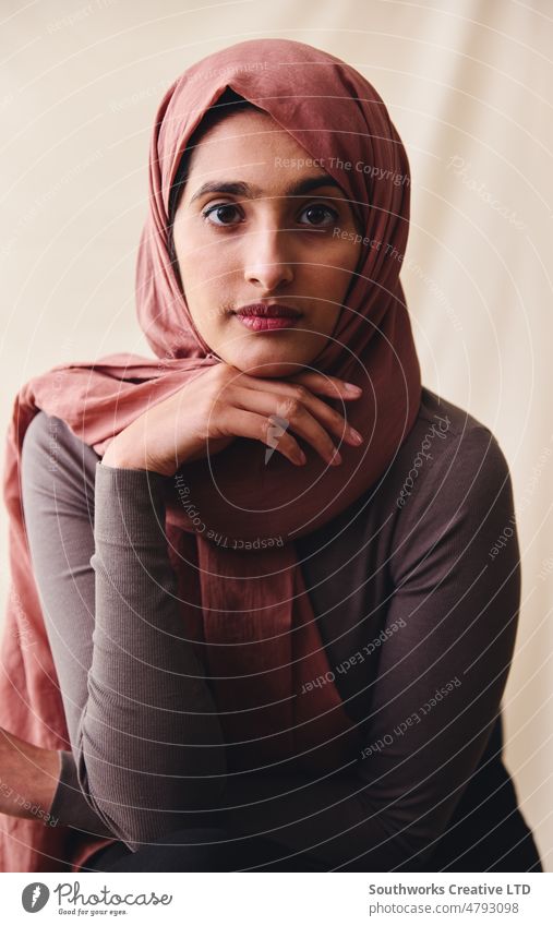 Porträt einer jungen muslimischen Frau, die einen Hidschab trägt und mit der Hand am Kinn in Richtung Kamera schaut nahöstlich Hijab Stolz selbstbewusst