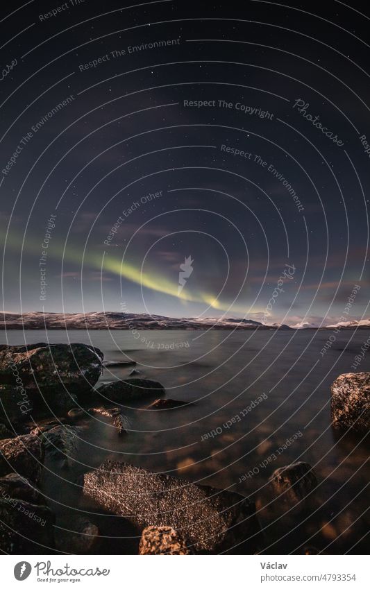 In einer wolkenlosen Nacht in Kilpisjarvi, Lappland, Finnland, zieht das Polarlicht Borealis über einen großen See hinweg. Skandinavische Magie Nordlicht