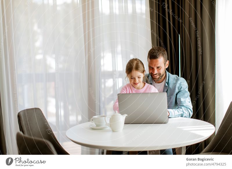 Vater und Tochter benutzen gemeinsam einen Laptop Erwachsener Browsen Kind Kindheit bequem Mitteilung Computer Papa Familie Mädchen Glück heimwärts