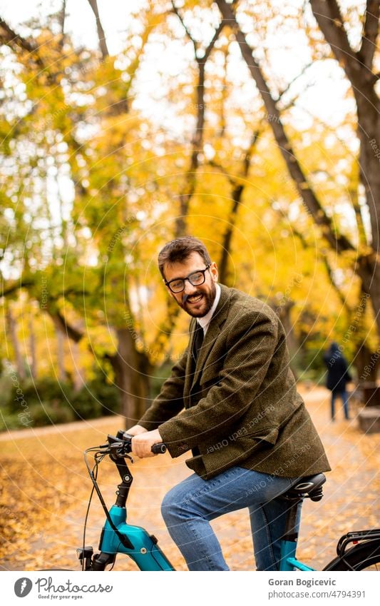 Junger Mann mit Elektrofahrrad im herbstlichen Park Fahrrad jung Natur elektrisch Lifestyle im Freien Aktivität Farbe Zyklus Mitfahrgelegenheit Sommer Tag