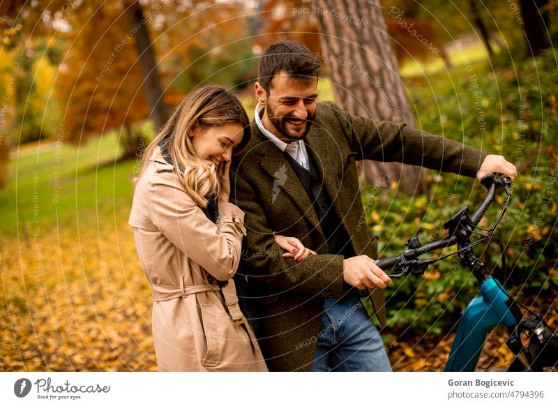 Junges Paar im herbstlichen Park mit Elektrofahrrad attraktiv Herbst schön Fahrrad Freund lässig Farbe Termin & Datum Datierung Tag e Fahrrad e-Bike ebike